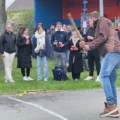 bild mit schlagball-spieler und zuschauenden am straßenrand